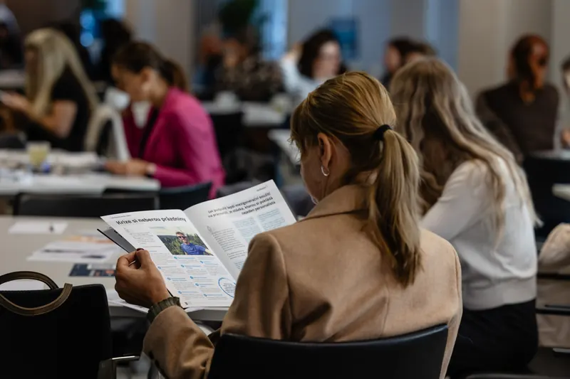 Účastnice konference čte časopis dobrokruhu o psychické první pomoci